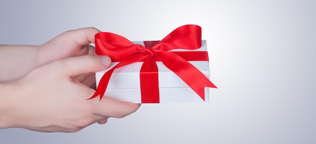 Woman holding a gift box in a gesture of giving