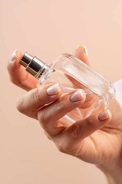 Woman holding glass parfume bottle atomizer fragrance aroma