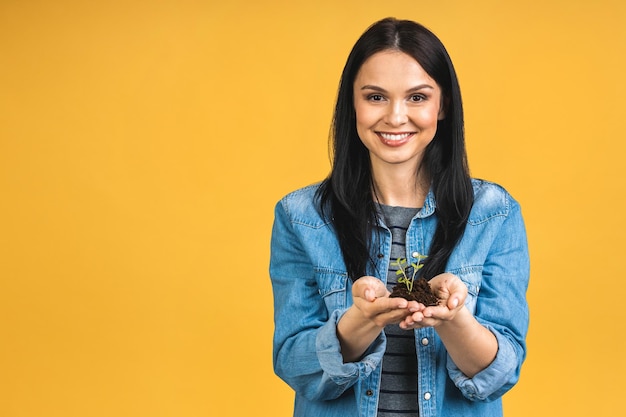 Woman holding a green plant in palm of her hand Woman holding a young fresh sprout