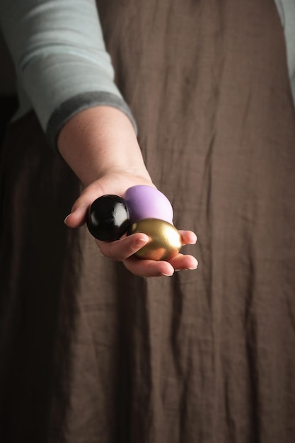 Woman holding a in hand Painted colored Eggs And Feathers For Easter