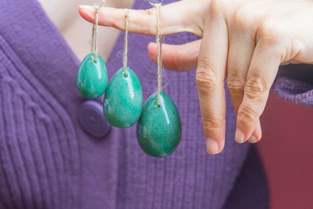 Woman holding in hand a vaginal yoni egg green quartz crystal egg