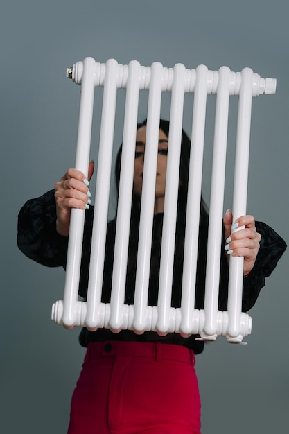 Woman holding a heating radiator in front of her face