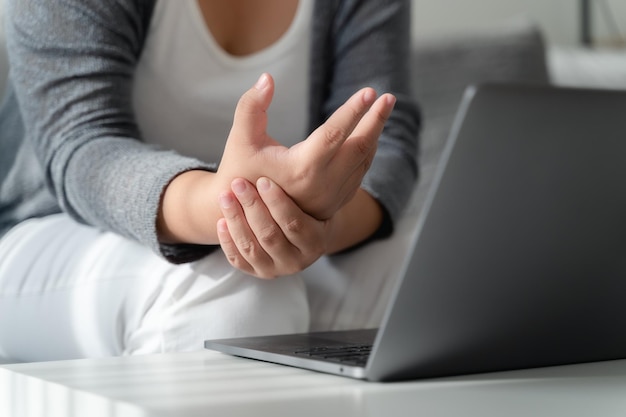 Woman holding her hand pain from using computer long time Office syndrome concept