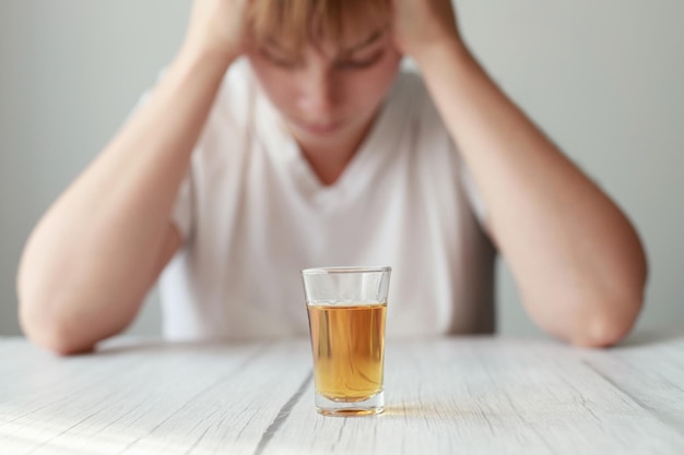 Woman holding her head against the background of strong alcohol