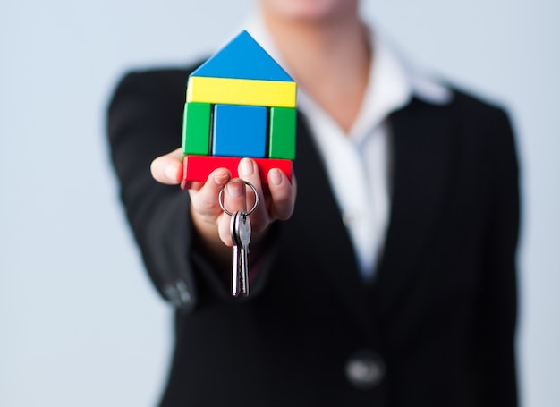 Woman holding house and dollars