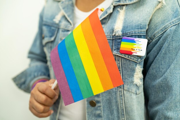 Woman holding LGBT rainbow colorful flag symbol of lesbian gay bisexual transgender human rights tolerance and peace