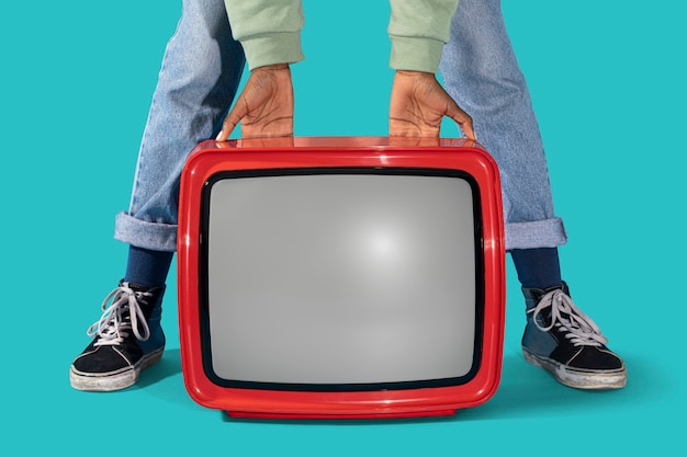 Woman holding an old red television