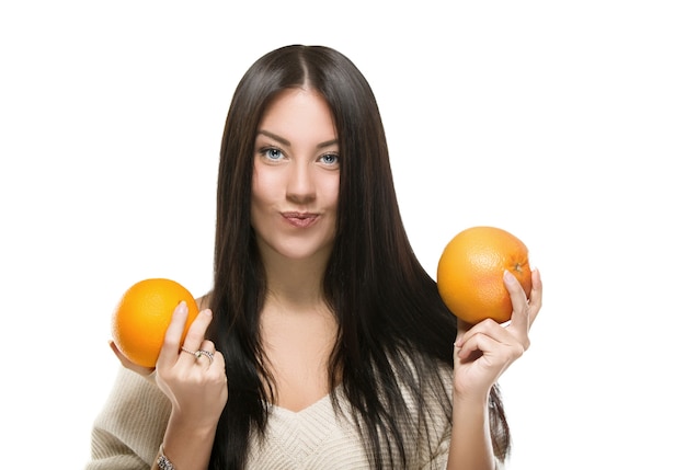 Woman holding orange and grapefruit over white