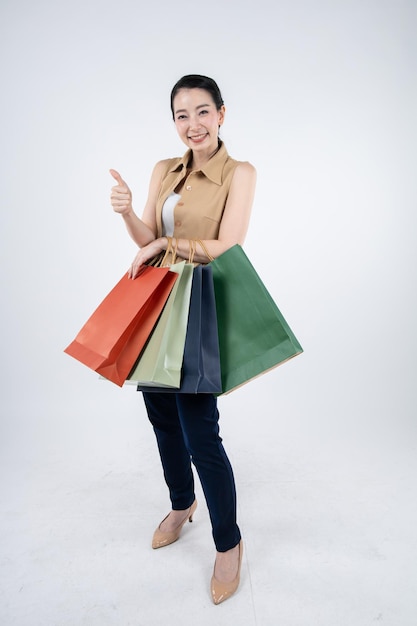 Woman holding paper bags with smile on white background in shopping concept