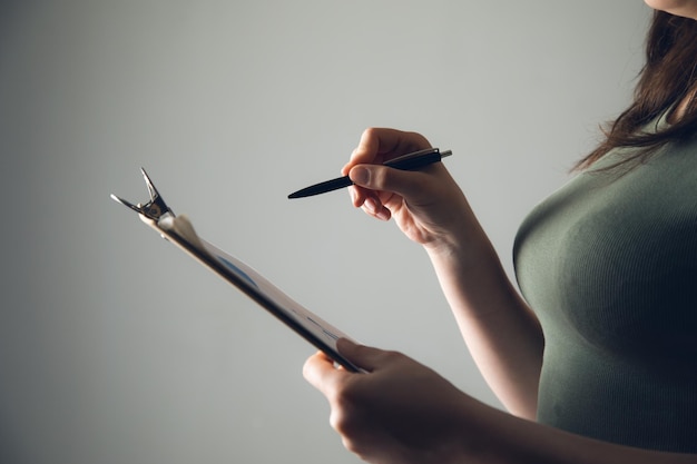 Woman holding pen with clipboard