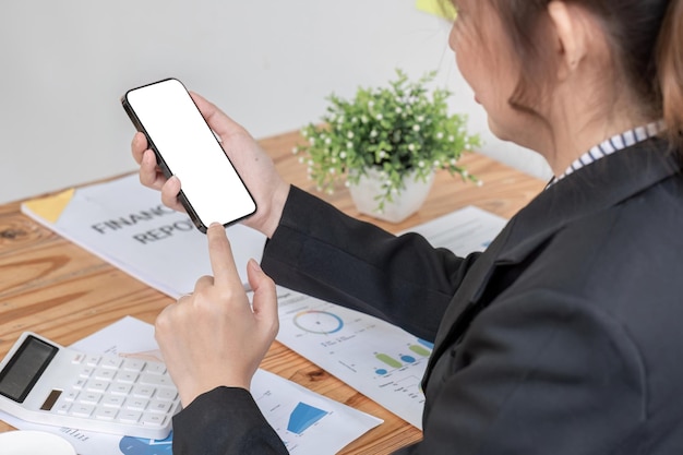 Woman holding phone showing white screen on top view while sitting in office