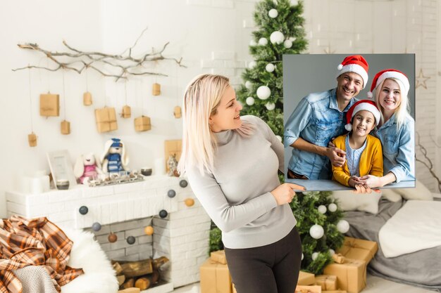 Woman holding a photo canvas on the background of a Christmas interior