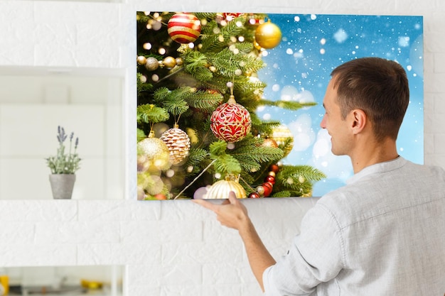 woman holding a photo canvas with a picture of christmas.