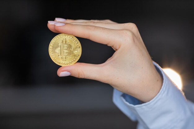 Woman holding a physical bitcoin cryptocurrency in her hand