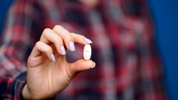 woman holding a pill in her hand