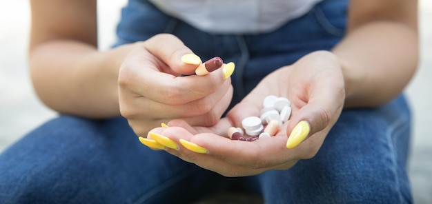 Woman holding pills in outdoor