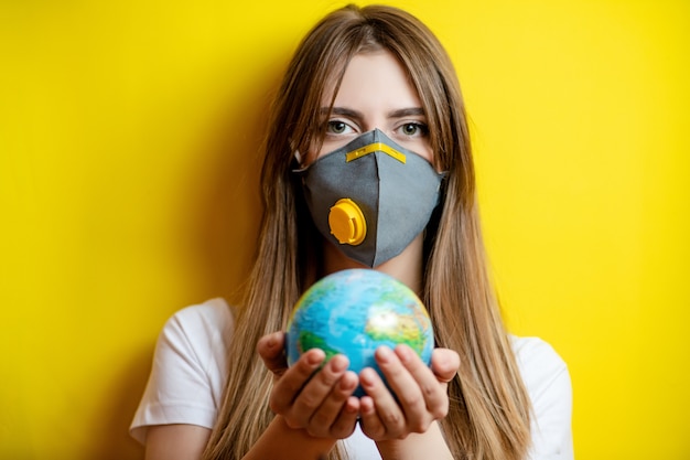 Woman holding planet earth globe wearing mask