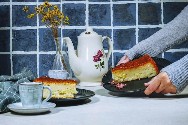 woman holding a plate with Homemade dessert rum baba with apricot jam decorated with gypsophila flow