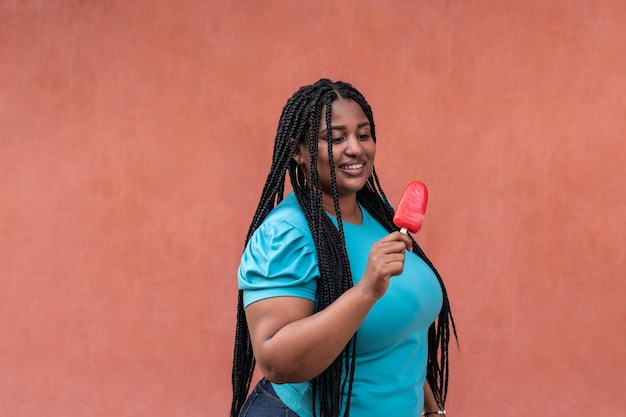 Woman holding a popsicle while walking down the street