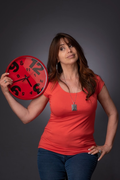 woman holding a red clock