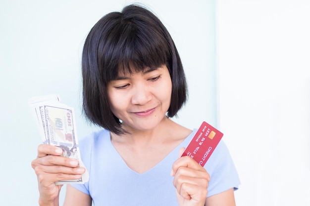 A woman holding a red credit card and a credit card