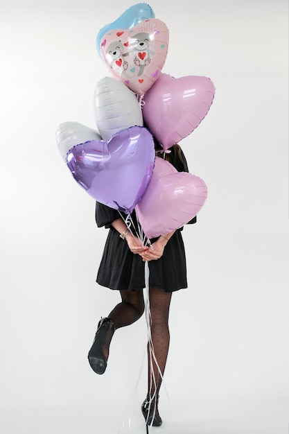 Woman Holding set of gel air balloons pink and violet colours for party Valentine's day on the white background.