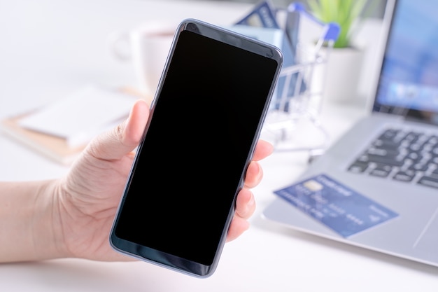 Woman holding a smart mobile phone for electronic payment shopping