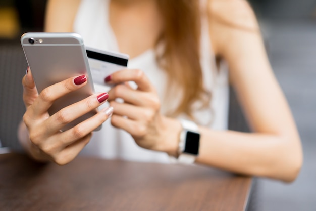 woman holding smartphone with credit card for pay online shopping concept