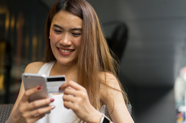 woman holding smartphone with credit card for pay online shopping e-commerce concept