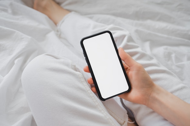 Woman holding a smartphone with a white screen