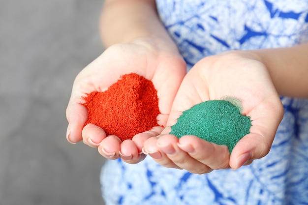 Woman holding spirulina and goji berry powder indoors closeup