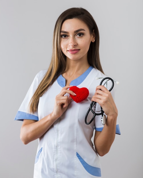 Woman holding a stethoscope and a plush heart