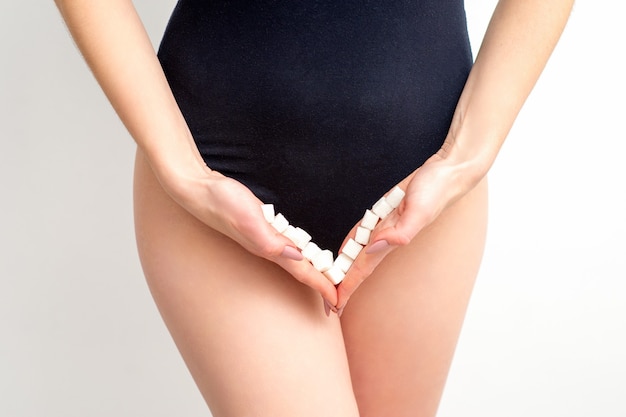 woman holding sugar cubes on bikini zone the concept of intimate depilation problems