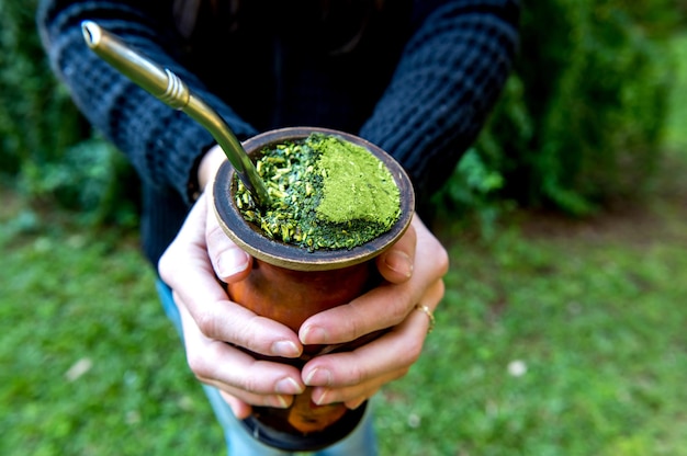 Woman holding a Traditional South American Yerba Mate tea chimarrao in Brazil