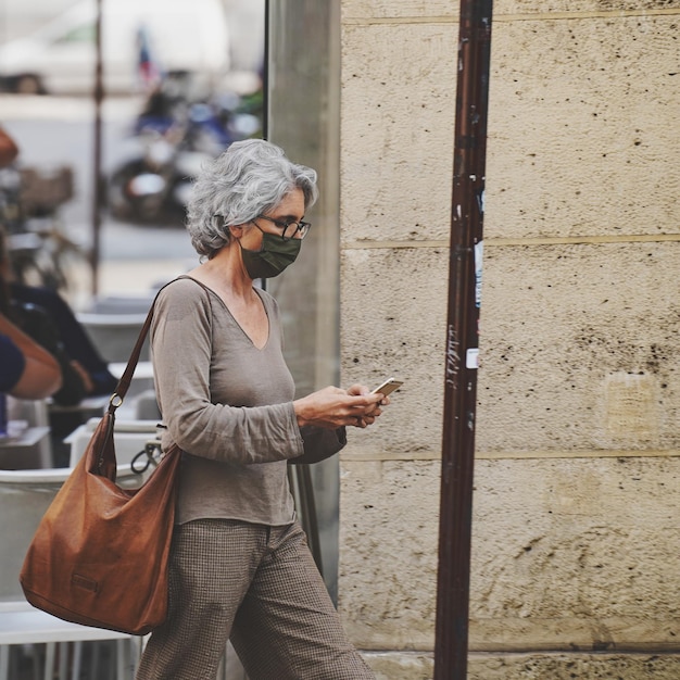 Photo woman holding umbrella while standing on mobile phone