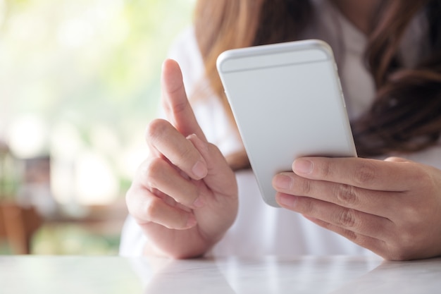 a woman holding, using and looking at smart phone 