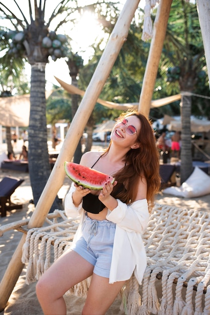 Woman holding watermelon slice medium shot