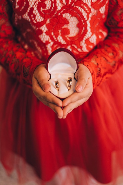 a woman holding a wedding rings in her hands