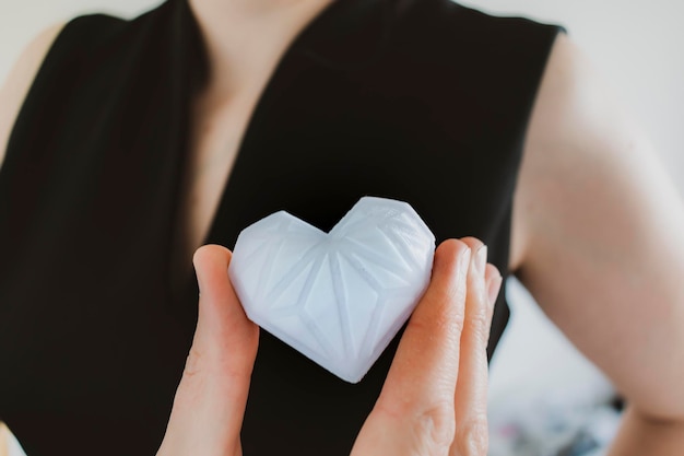 Woman holding white 3d printed heart concept love and health gratitude and charity either technology