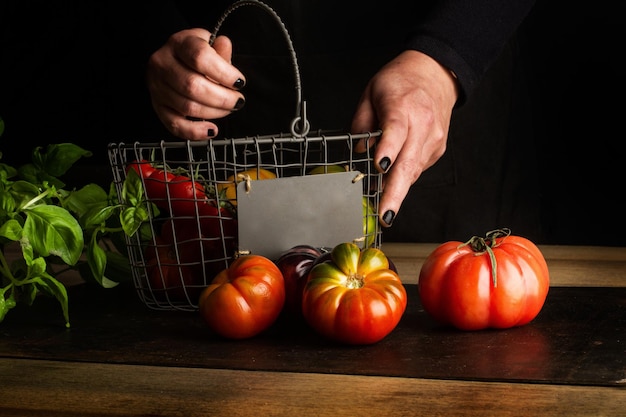 A woman holds a basket of tomatoes and a sign that says'organic '