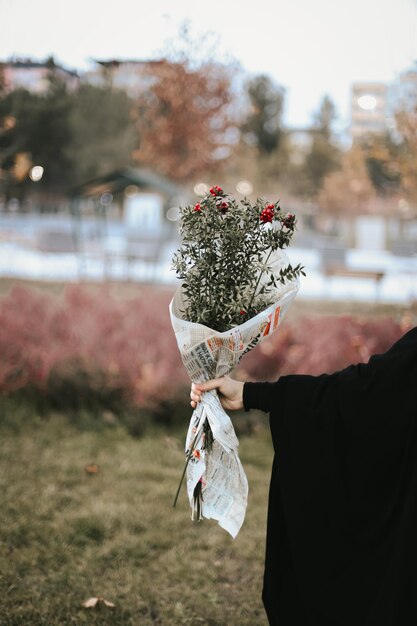 A woman holds a bouquet of flowers in her hands.