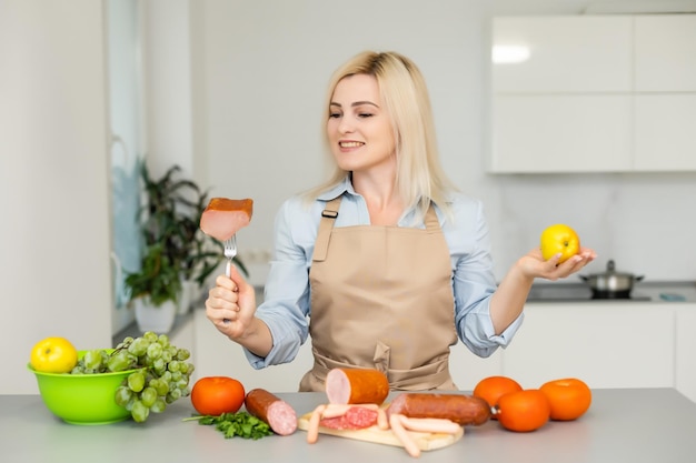 woman holds and chooses between meat and apple