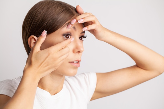 Woman holds contact lens on her finger eye care and the choice between the means to improve vision