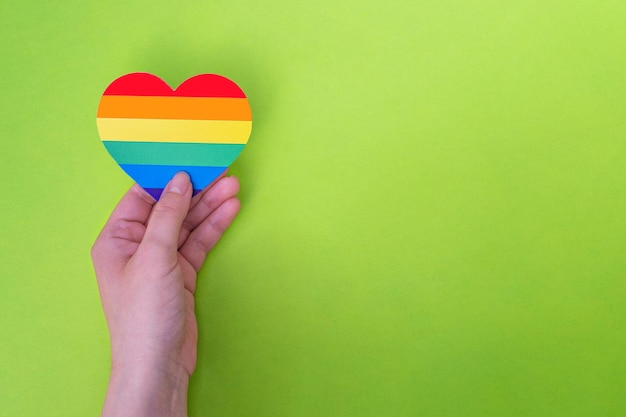 Woman holds in hands a heart in the colors of the rainbow Pride Month LGBTIQ flag Love human rights tolerance