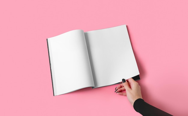 A woman holds a magazine or catalog in A4 format with white sheets in her hand