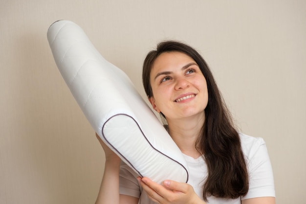 A woman holds an orthopedic pillow