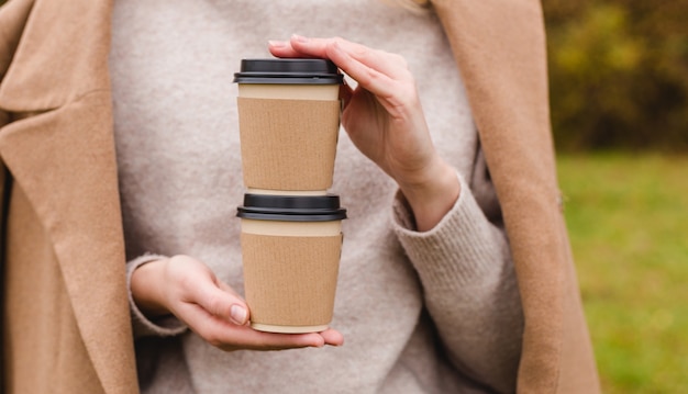 Woman holds two paper coffee cups