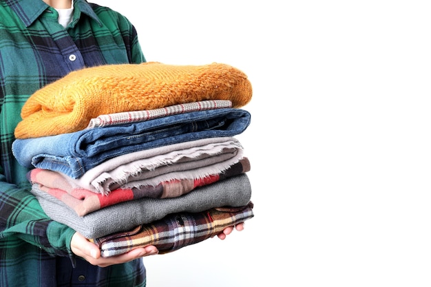 Woman holds winter clothes, isolated on white background.