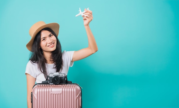 Woman holidays travel concept her holding fly toy aircraft her have suitcase bag