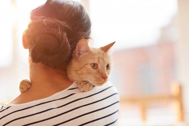 Woman Hugging Ginger Cat Back View